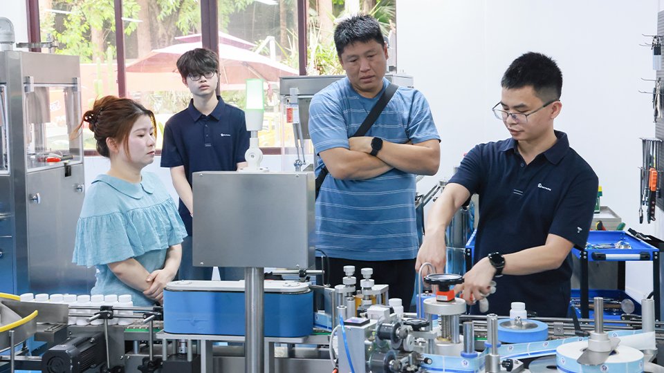 Simon is showing how the labeling machine works