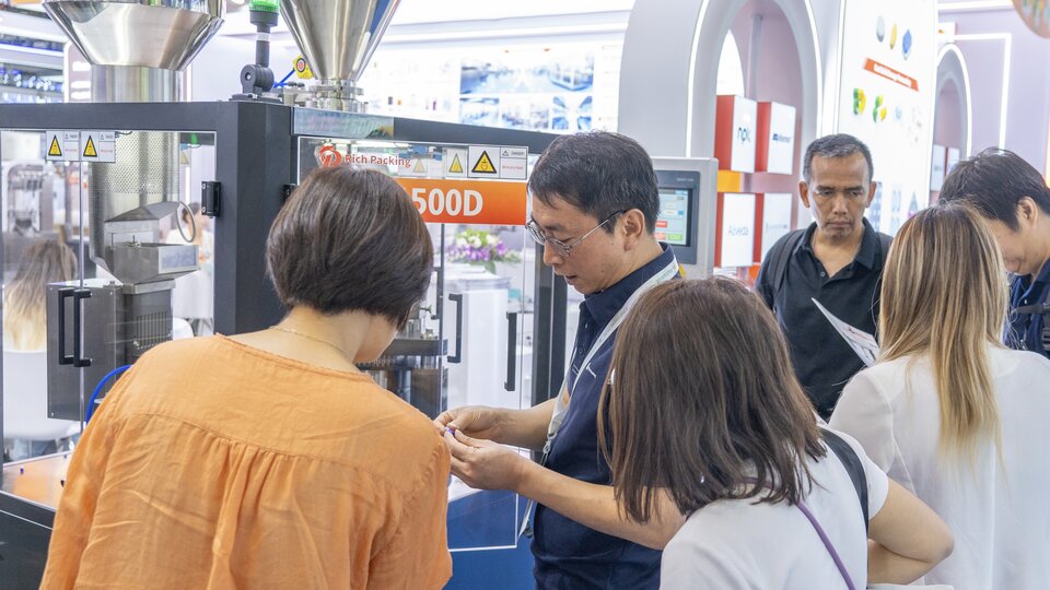 Our engineer in deep conversation with visitors about the Fully Automatic Capsule Filling Machine